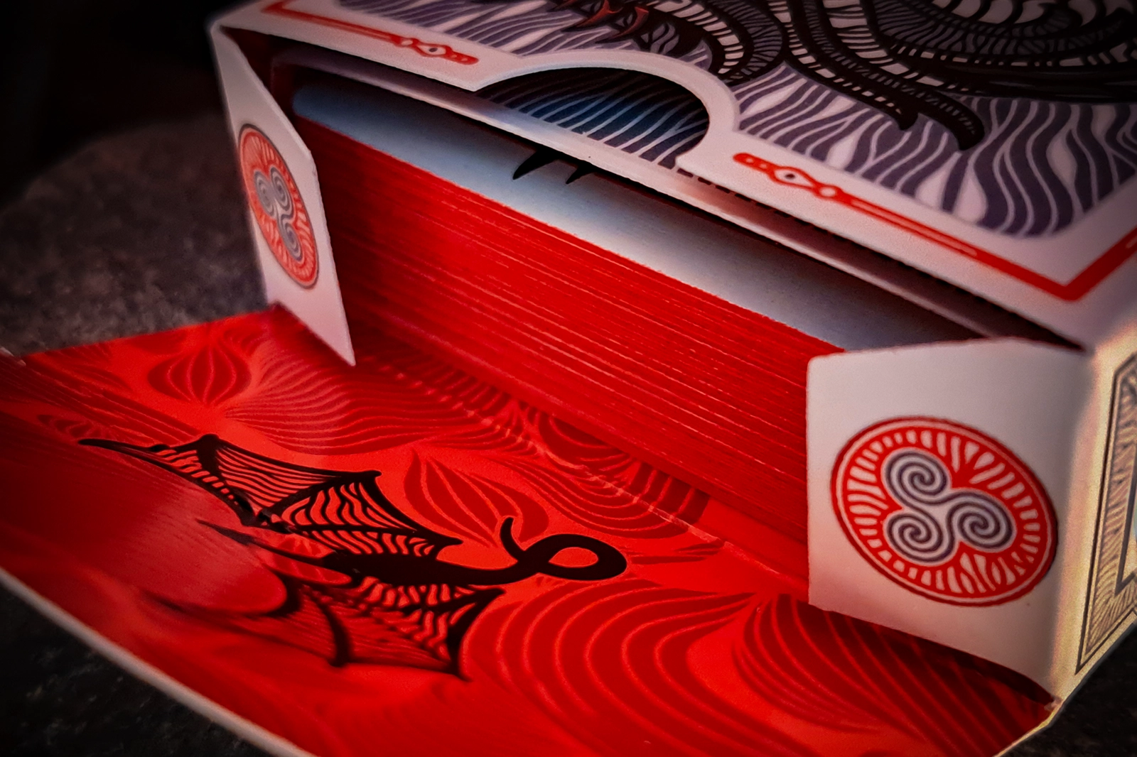 A deck of 55 poker format cards representing a more grim and ominous side of the Edge of Chaos. Red and black are the dominant colors. The deluxe version is packed in a special tuck box adorned with red synthetic stone. The edges of the cards are painted red.